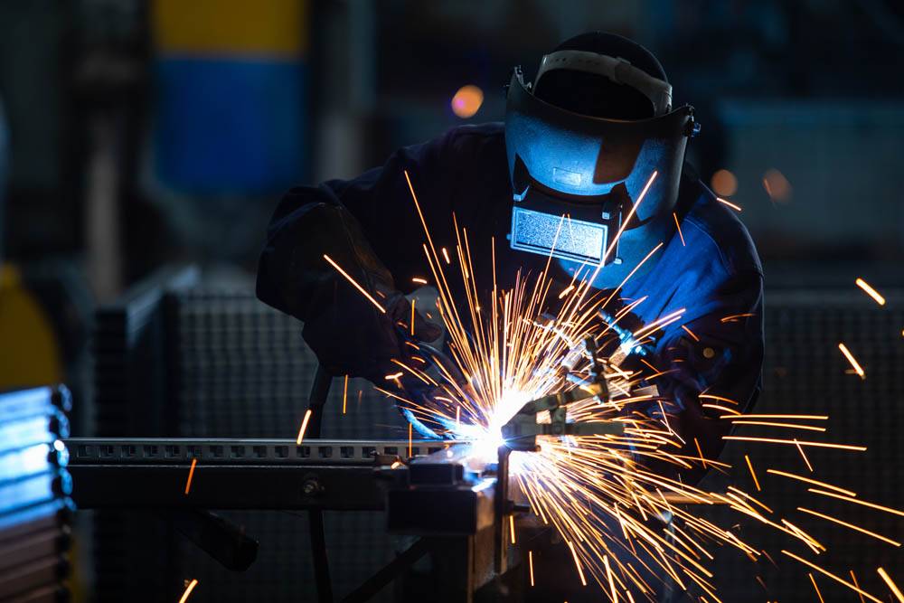 Workers wearing industrial uniforms and Welded Iron Mask at Stee