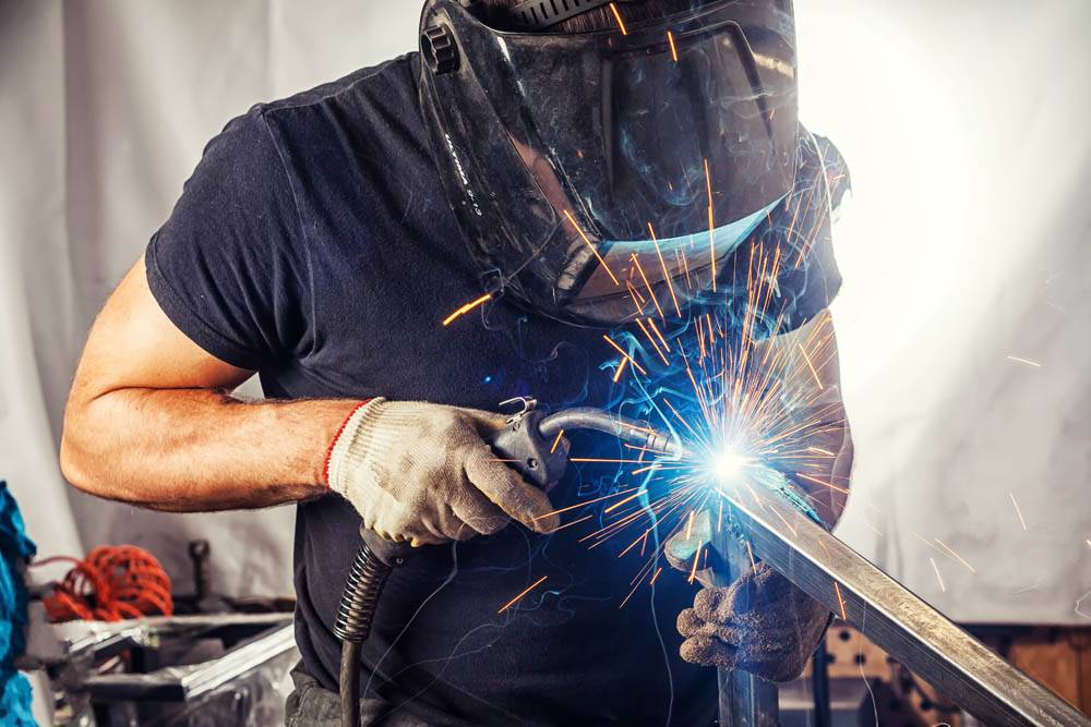 man weld a metal with a welding machine