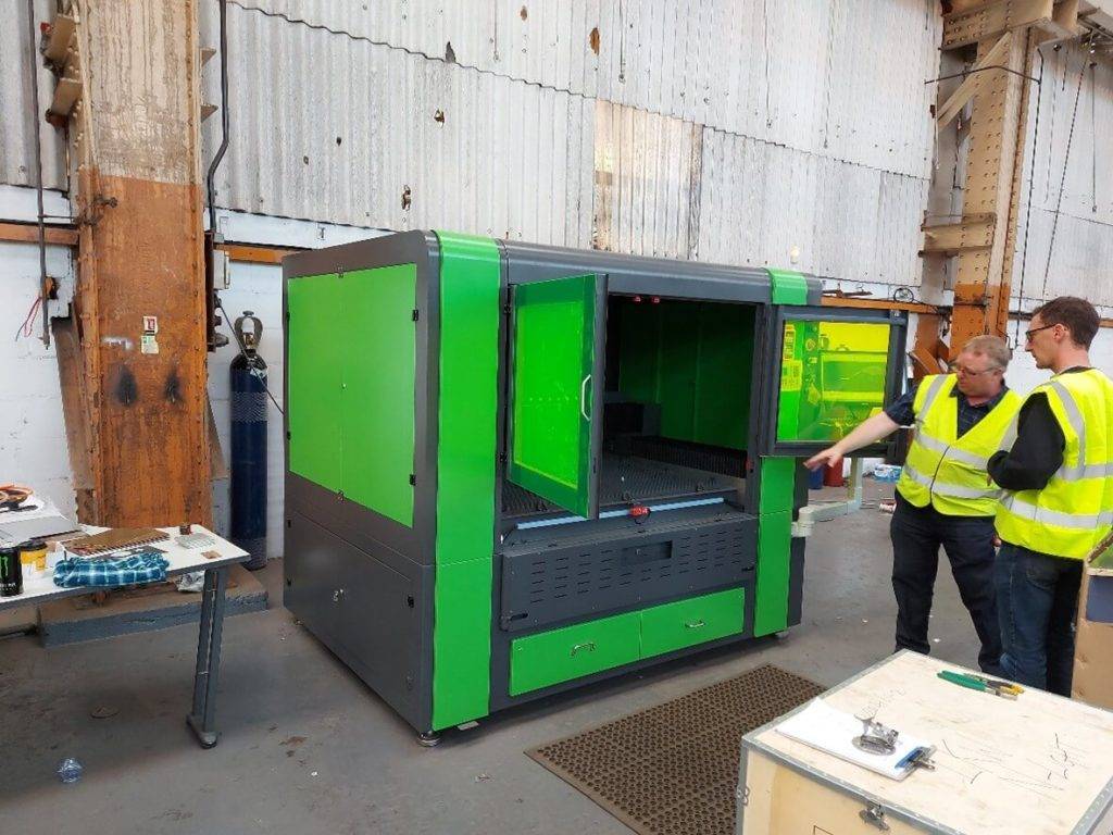 large laser cutting machine with people looking at it