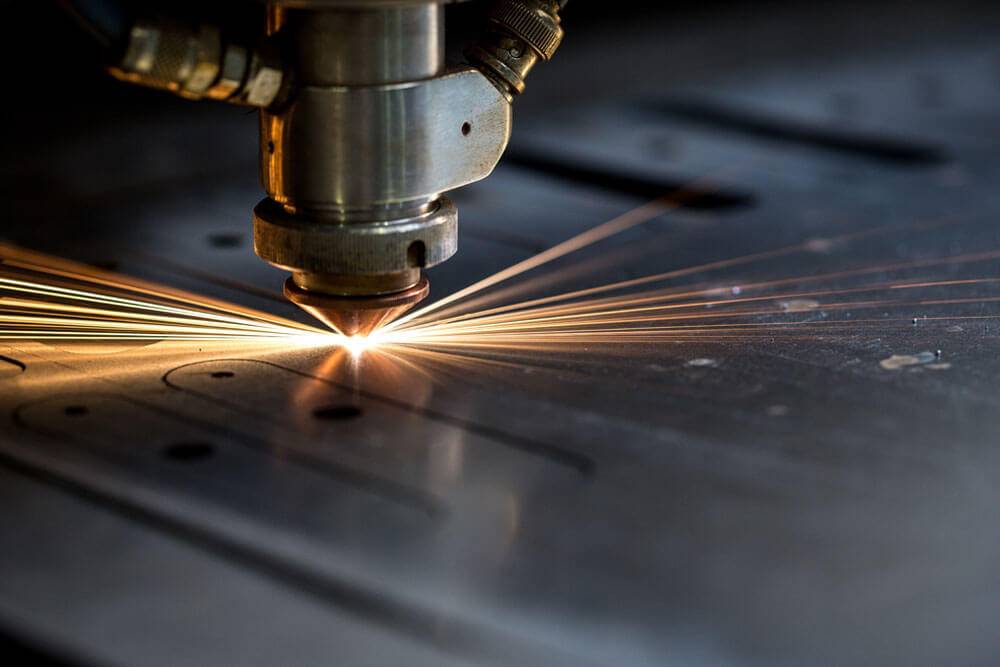 laser cutting nib on a piece of metal with sparks coming off